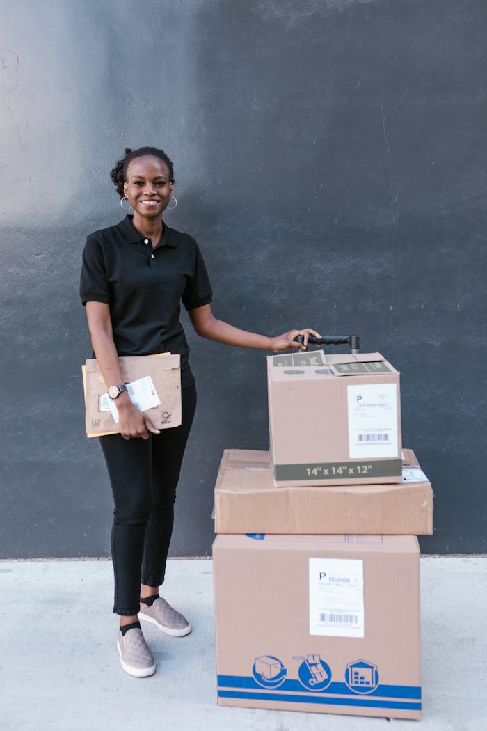 Services African American woman delivering packages with a smile, using a trolley cart.