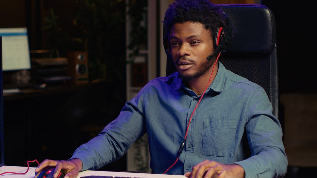 man playing intense game on rgb lit computer desktop, talking with fans during livestream